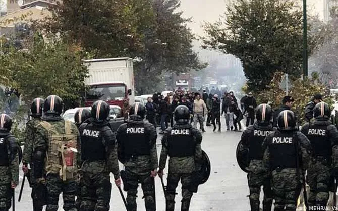 Image of Iranian police standing in a line in front of demonstrators